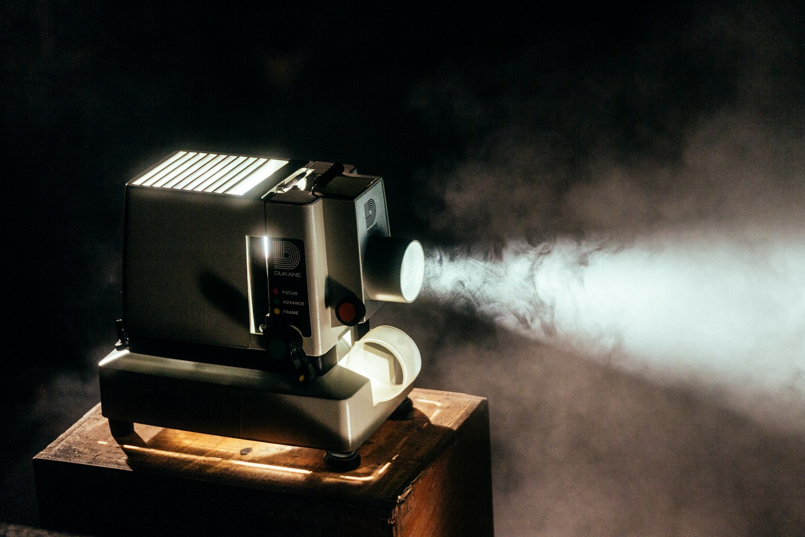 Proiettore acceso su una cassa di legno. Un fascio di luce attraversa il fumo.